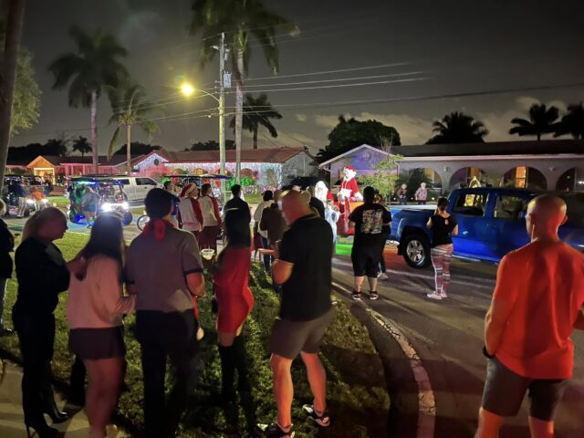 Families gathered on the grass at night waiting for Santa
