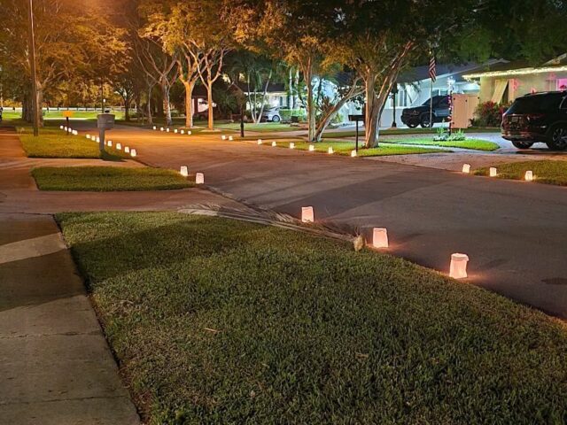Light Up the Creek: a row of luminaries along the street as the sun goes down